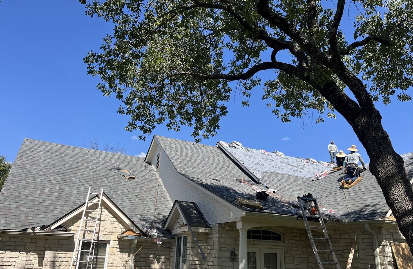 Home Glow Exteriors crew installing a new roof on a stone home